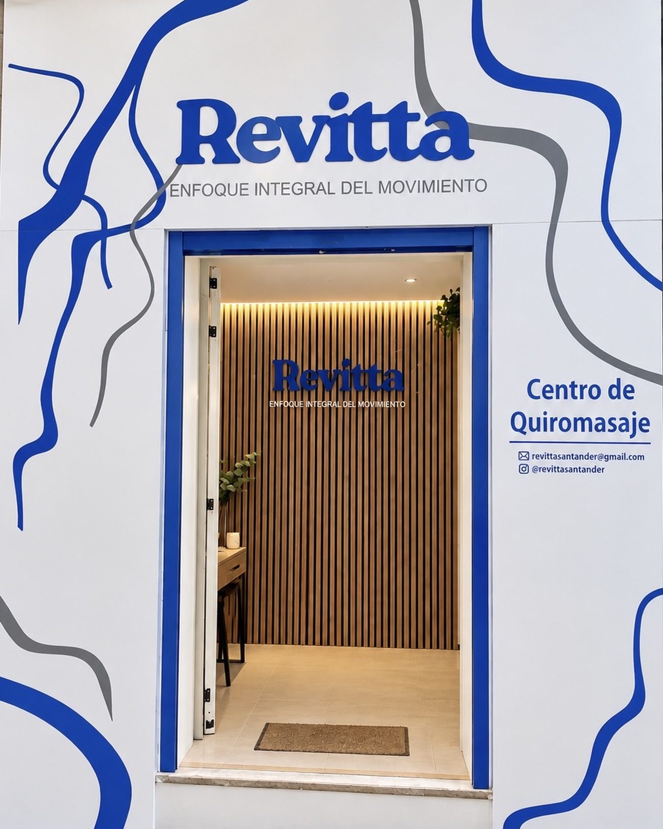 Fachada de Revitta en la Cuesta de la Atalaya, Santander, con el rótulo azul y la puerta abierta